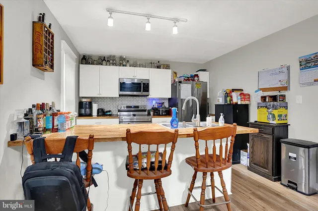 a dining room filled with furniture and a kitchen view