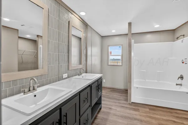 a bathroom with 2 sink tub and a mirror