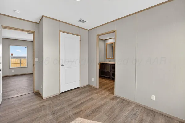 an empty room with wooden floor and closet