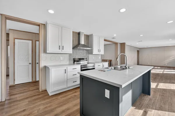 a kitchen with a sink a stove a refrigerator and white cabinets