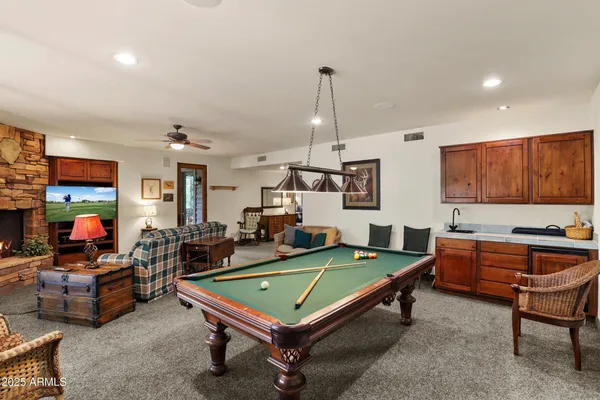 a living room with furniture pool table and a flat screen tv
