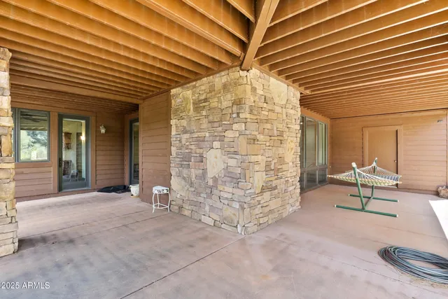 a roof deck with table and chairs and potted plants