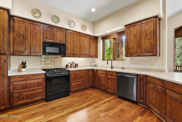 a kitchen with stainless steel appliances granite countertop a stove sink microwave and window