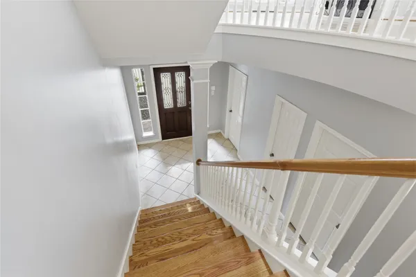 a view of a hallway with wooden floor and staircase