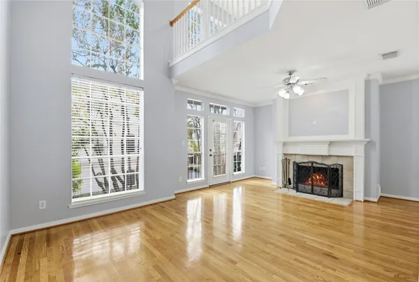a view of an empty room with wooden floor fireplace and a window