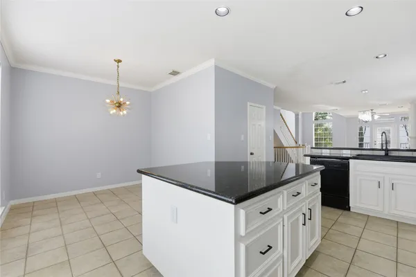 a kitchen with granite countertop a sink a counter space and cabinets