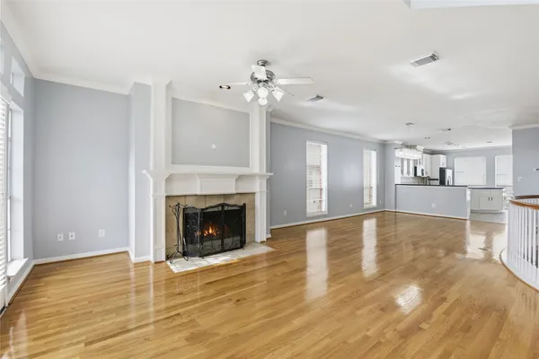 a view of a livingroom with a fireplace a chandelier and wooden floor