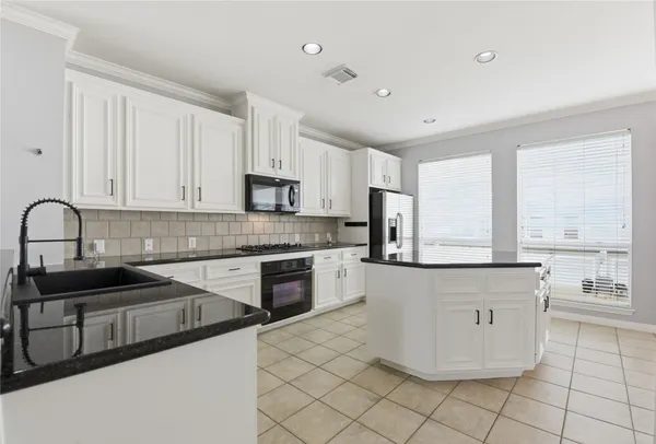 a kitchen with granite countertop white cabinets and appliances