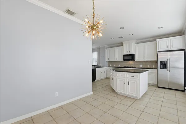 a kitchen with granite countertop white cabinets and stainless steel appliances