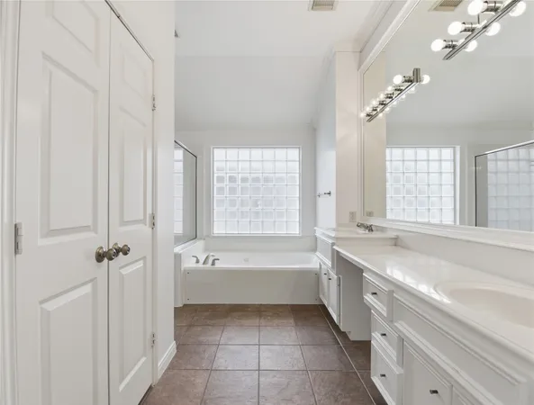 a spacious bathroom with a tub sink and mirror