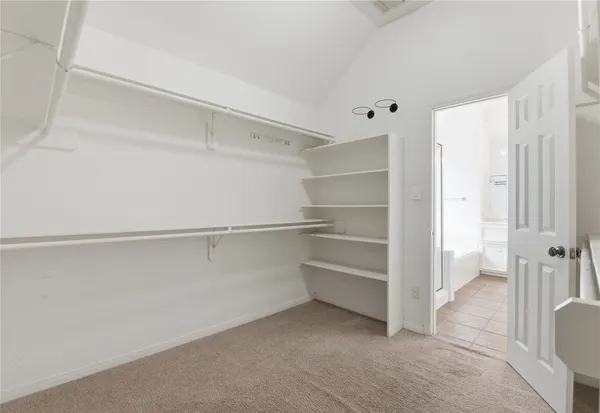 a view of walk in closet with empty racks
