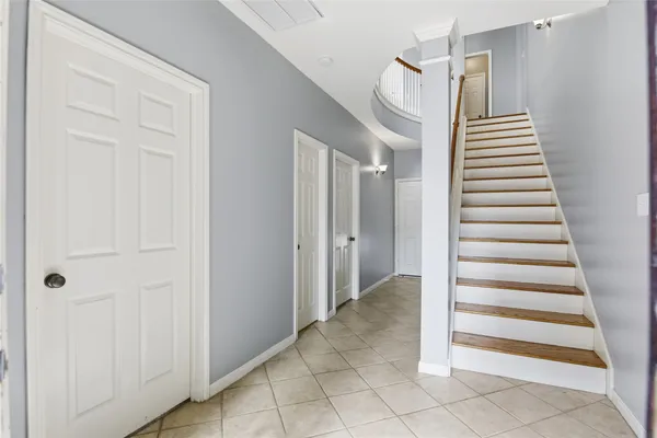 a view of a hallway with entryway and stairs