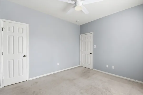 an empty room with a ceiling fan and a window