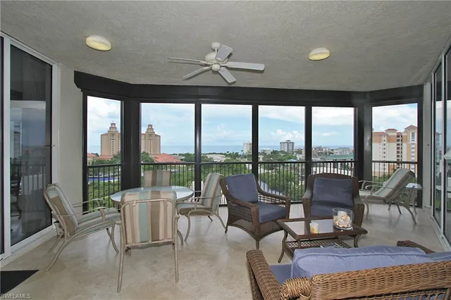 a living room with furniture and floor to ceiling windows