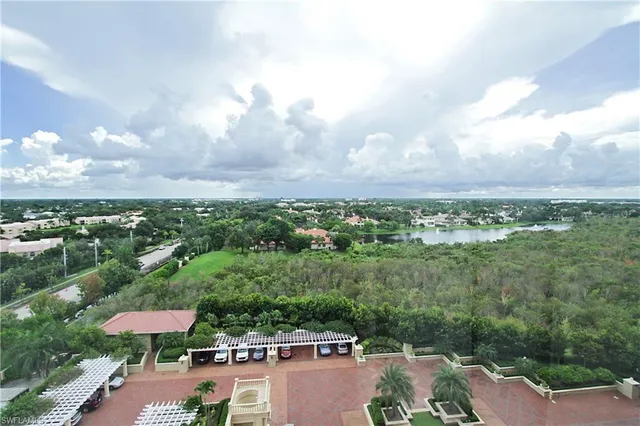 an aerial view of a city with lots of residential buildings ocean and mountain view in back