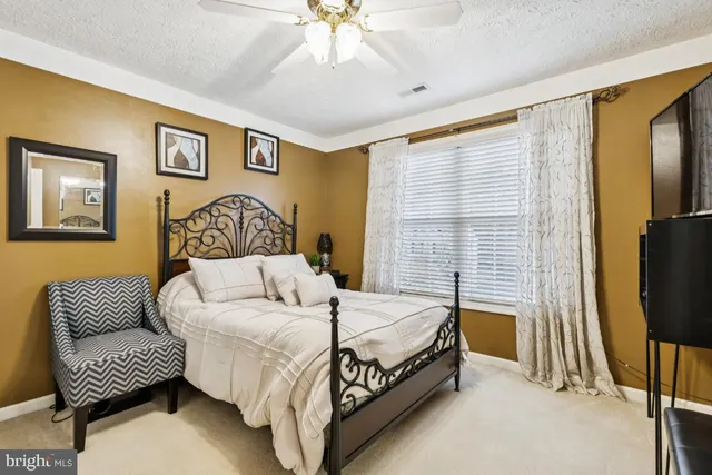 a bedroom with a bed couch and a flat screen tv