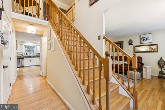 a view of staircase with lots of frames on wall and wooden floor