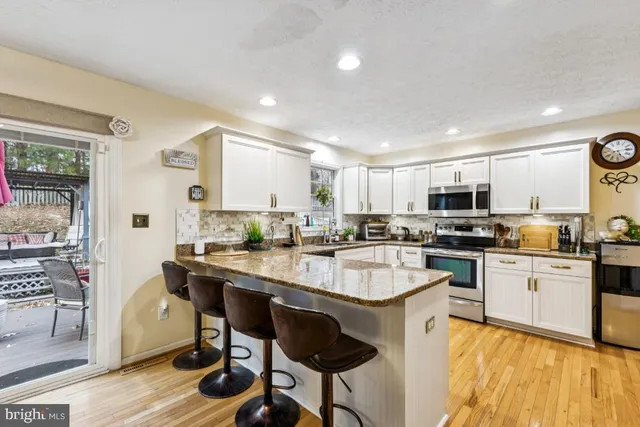 a large kitchen with kitchen island a sink table and chairs