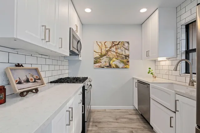 a kitchen with a sink a stove and cabinets
