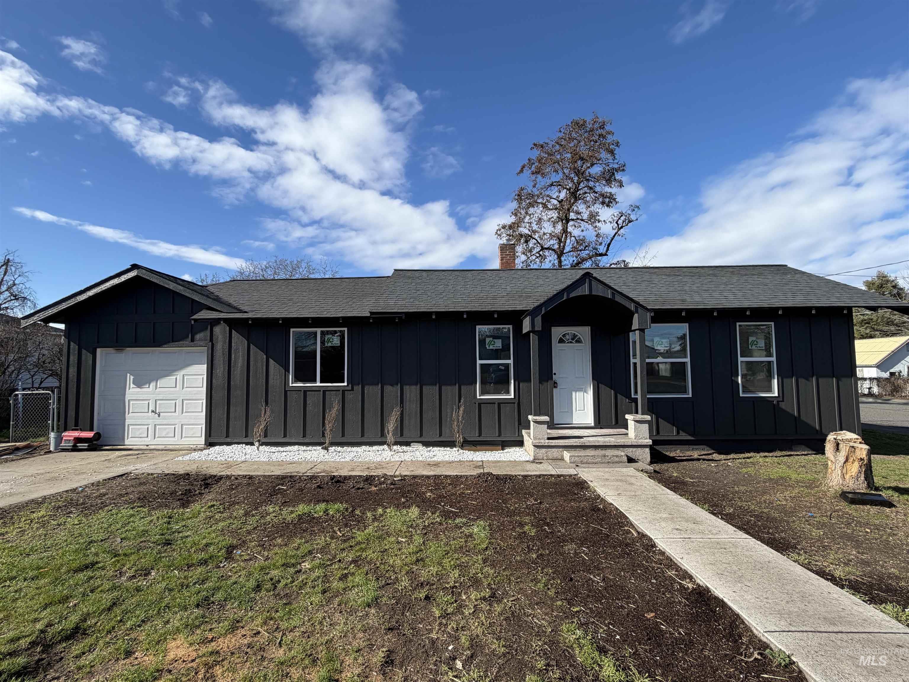600 11th Street Clarkston, WA 99403 - Photo 3 of 27 Ranch-style home with board and batten siding, a garage, roof with shingles, driveway, and a chimney