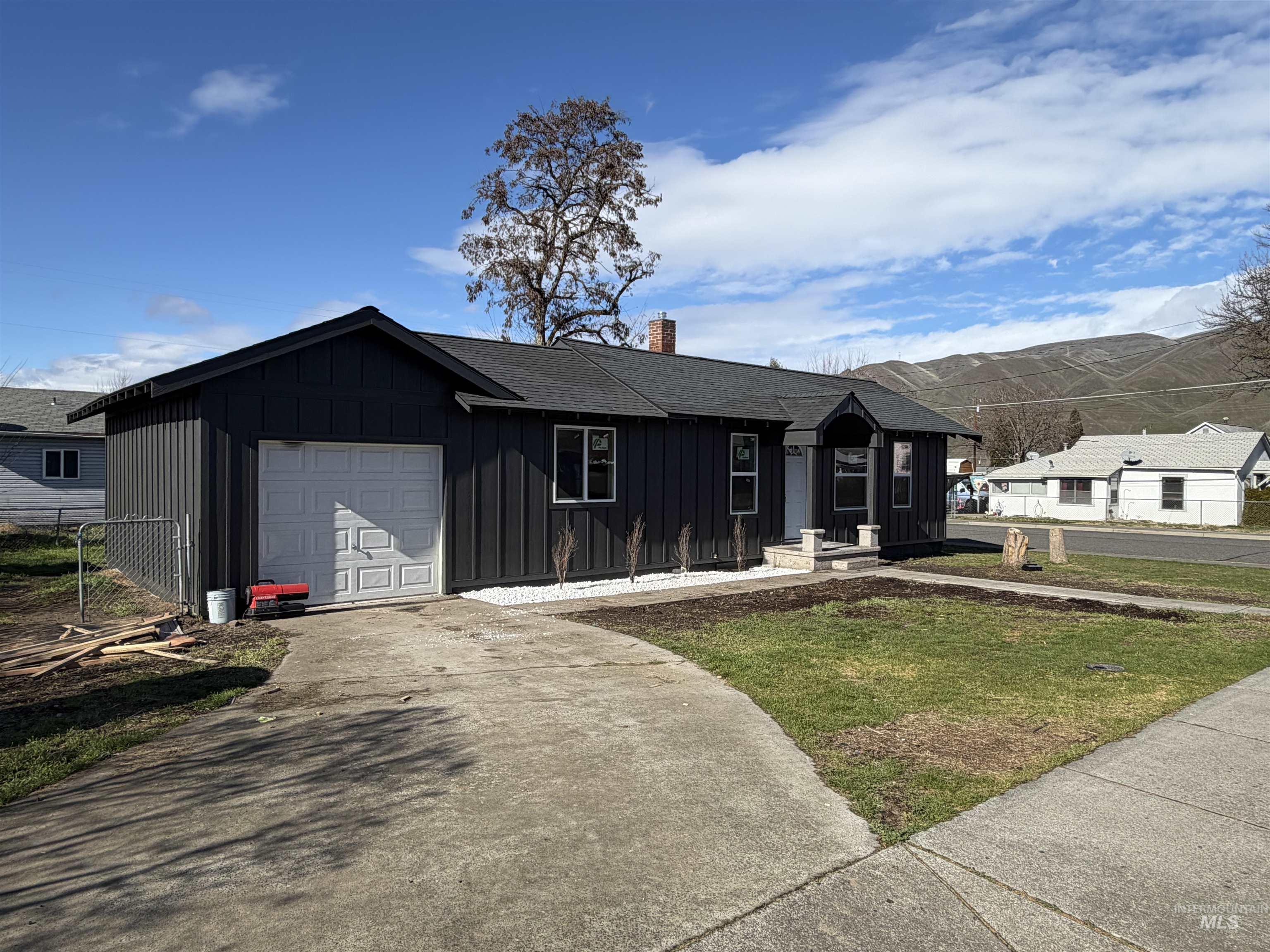 600 11th Street Clarkston, WA 99403 - Photo 4 of 27 View of front of house with board and batten siding, driveway, a chimney, and an attached garage