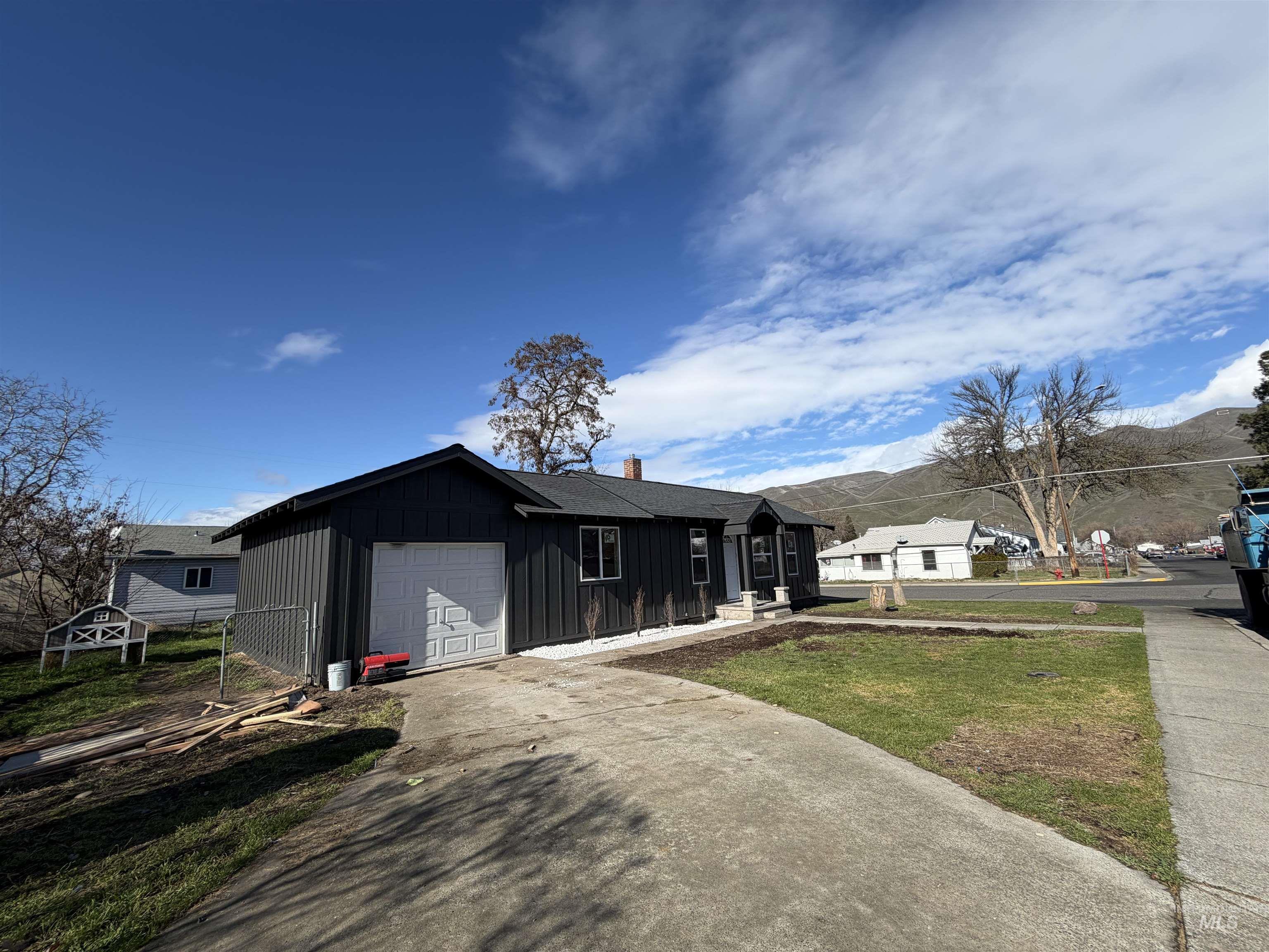 600 11th Street Clarkston, WA 99403 - Photo 5 of 27 Ranch-style home with board and batten siding, driveway, a chimney, a front lawn, and an attached garage