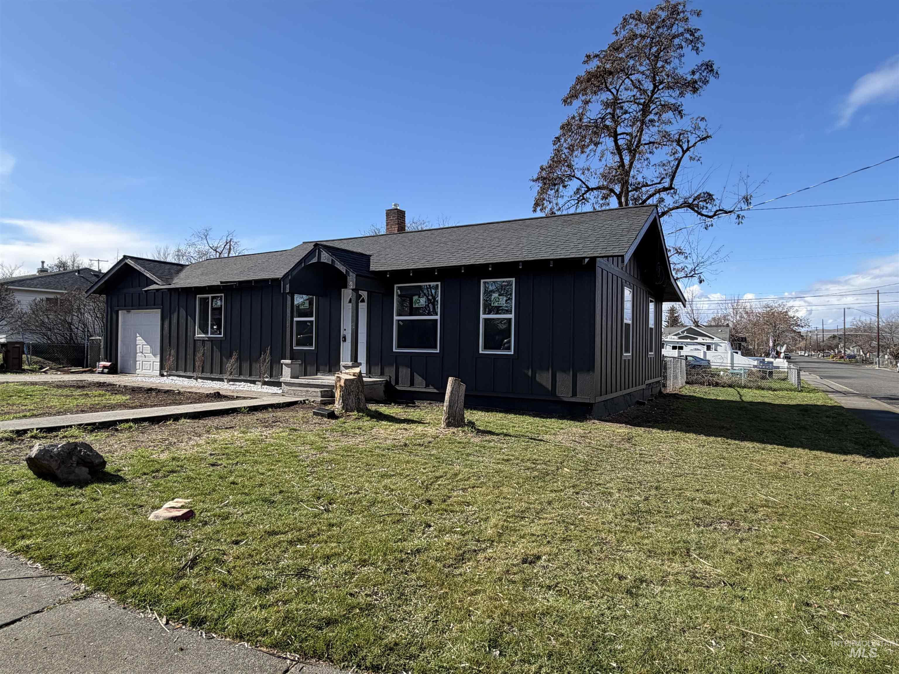 600 11th Street Clarkston, WA 99403 - Photo 6 of 27 View of front of house with board and batten siding, a shingled roof, a chimney, a front lawn, and an attached garage