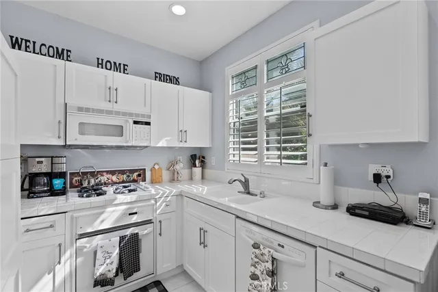a kitchen with cabinets appliances a sink and a window