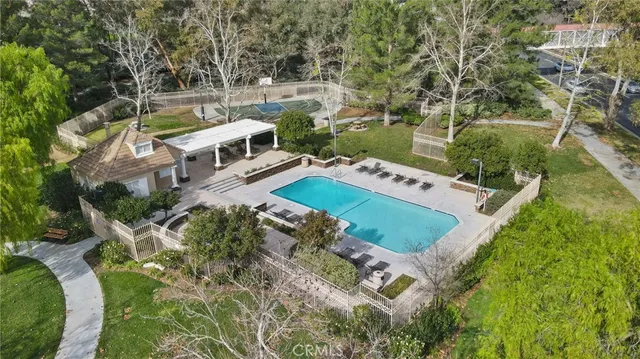an aerial view of residential house with outdoor space and trees all around