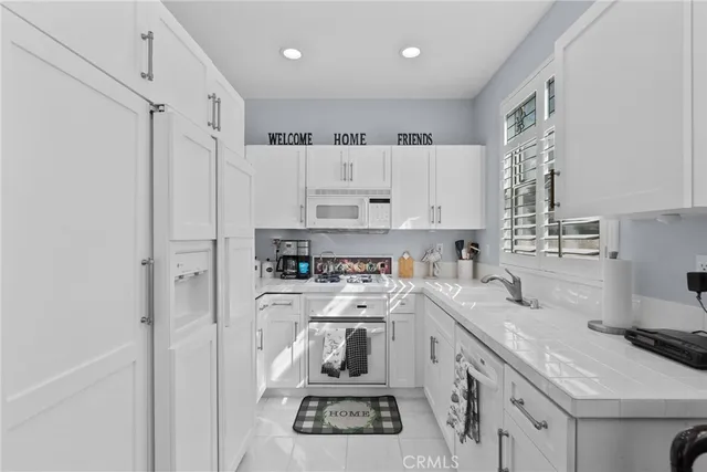 a kitchen with white cabinets and white appliances