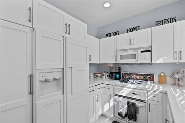 a kitchen with white cabinets and white appliances