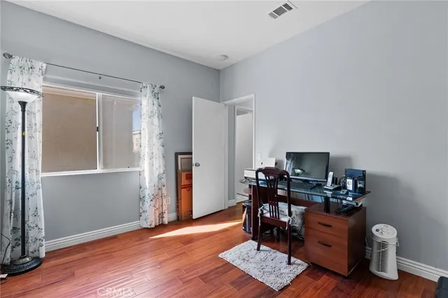 a view of workspace with wooden floor windows cabinet