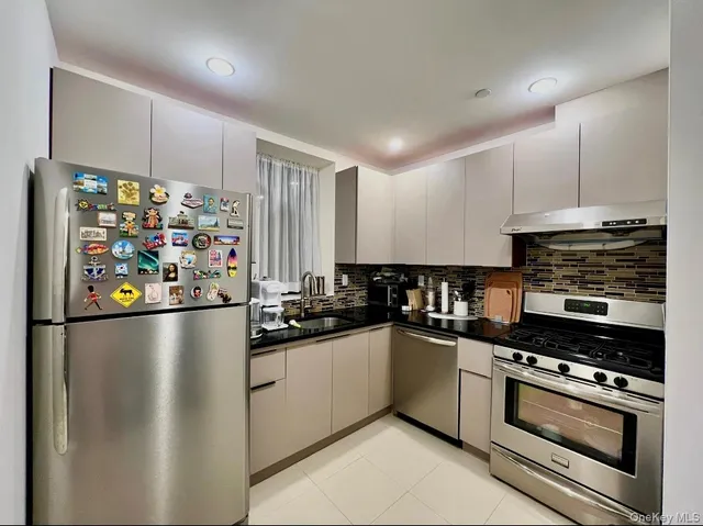 a kitchen with stainless steel appliances a refrigerator sink and cabinets