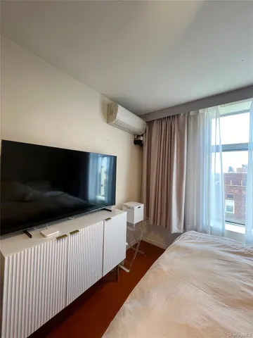 a bedroom with a bed and a television