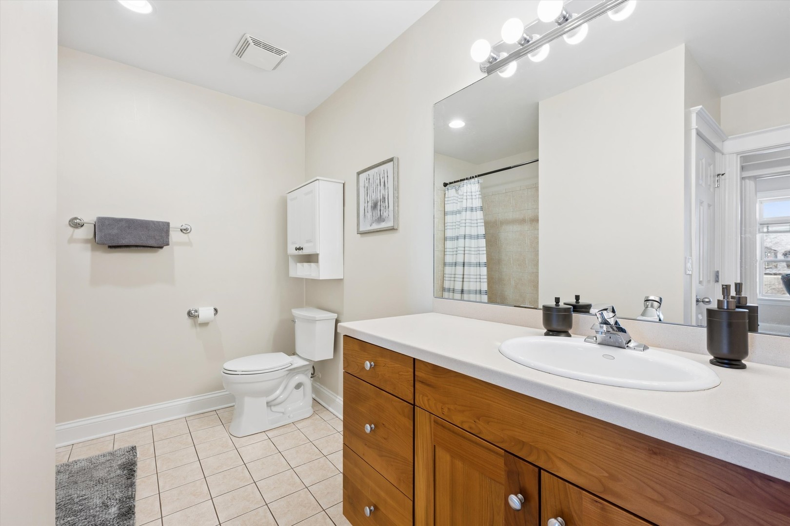 3755 North Racine Avenue, Unit 3C Chicago, IL 60613 - Photo 26 of 36 a bathroom with a sink a toilet a large mirror and shower