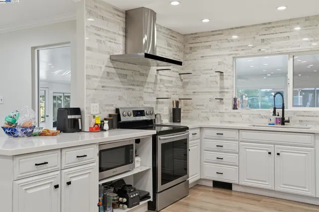 a kitchen with stainless steel appliances granite countertop a sink stove and microwave