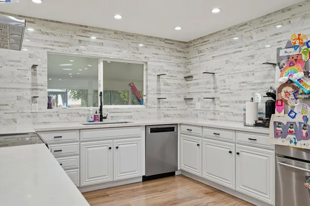 a kitchen with a dining table chairs and flat screen tv