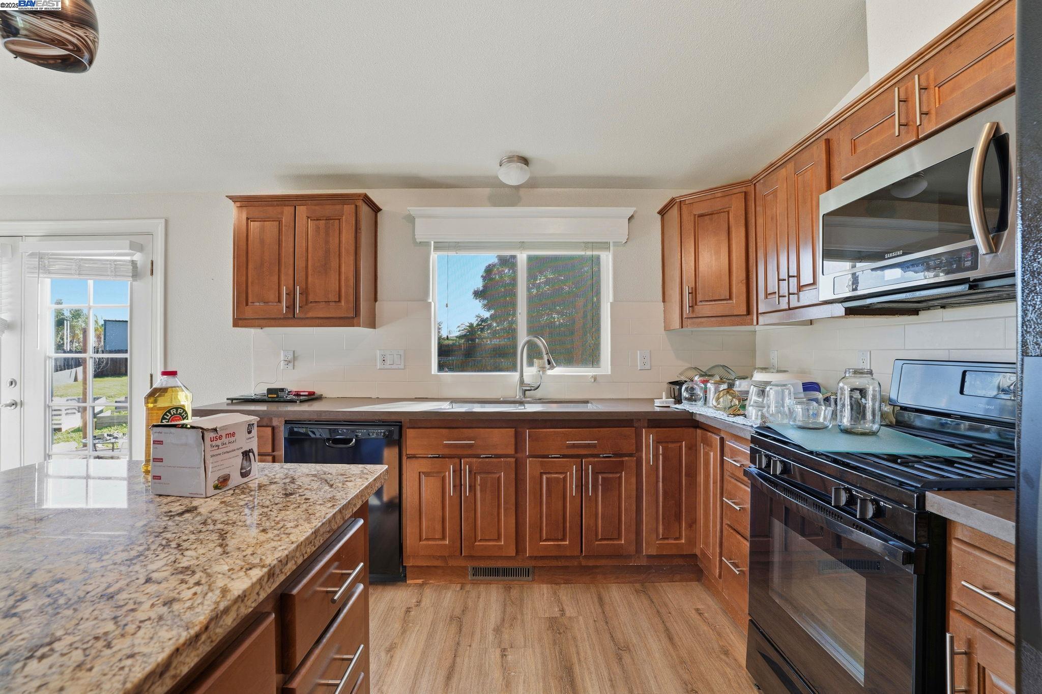 34724 Bernard Road Tracy, CA 95377 - Photo 19 of 60 a kitchen with stainless steel appliances granite countertop a sink stove and microwave