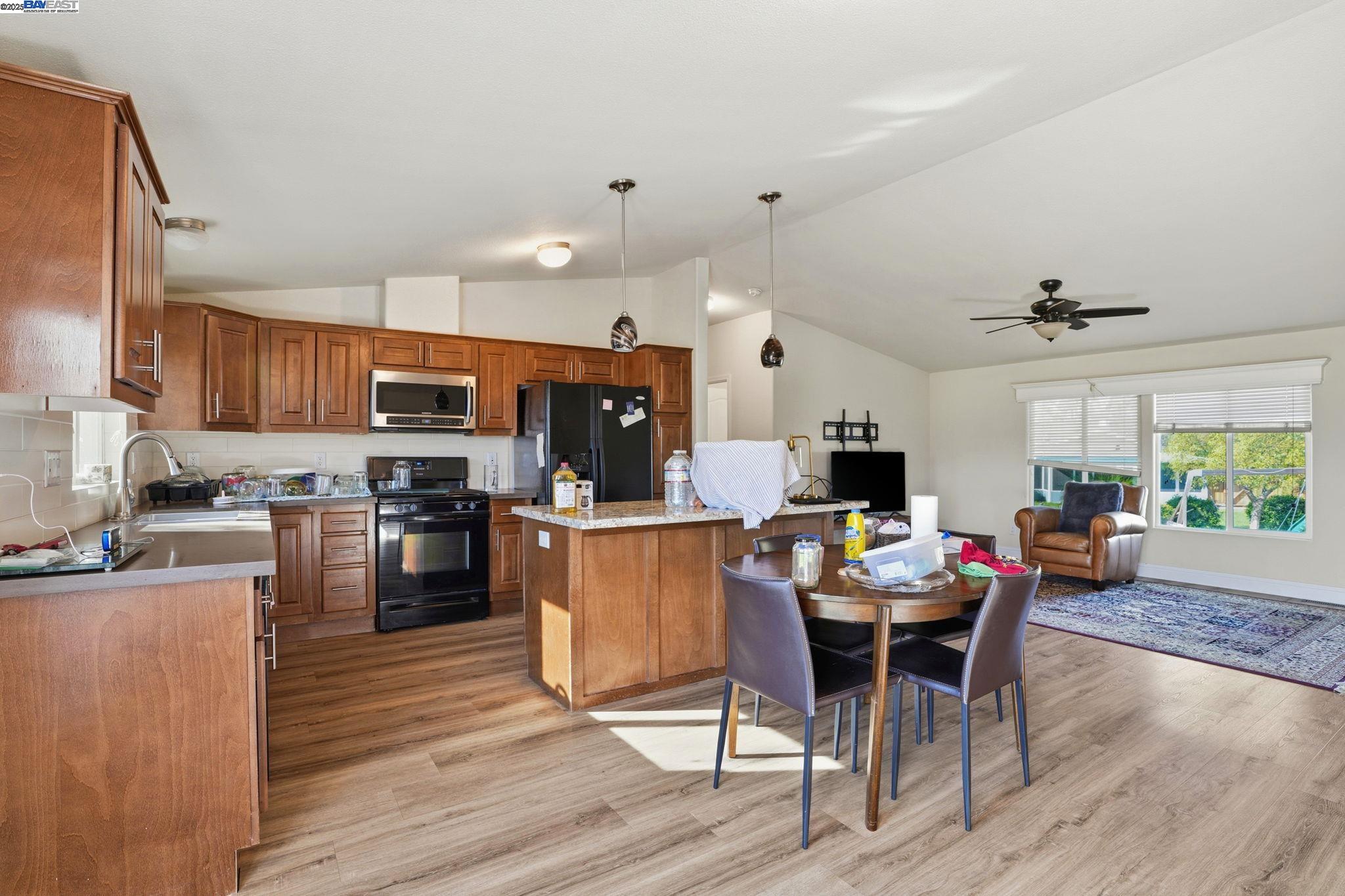 34724 Bernard Road Tracy, CA 95377 - Photo 20 of 60 a kitchen with a dining table chairs and flat screen tv