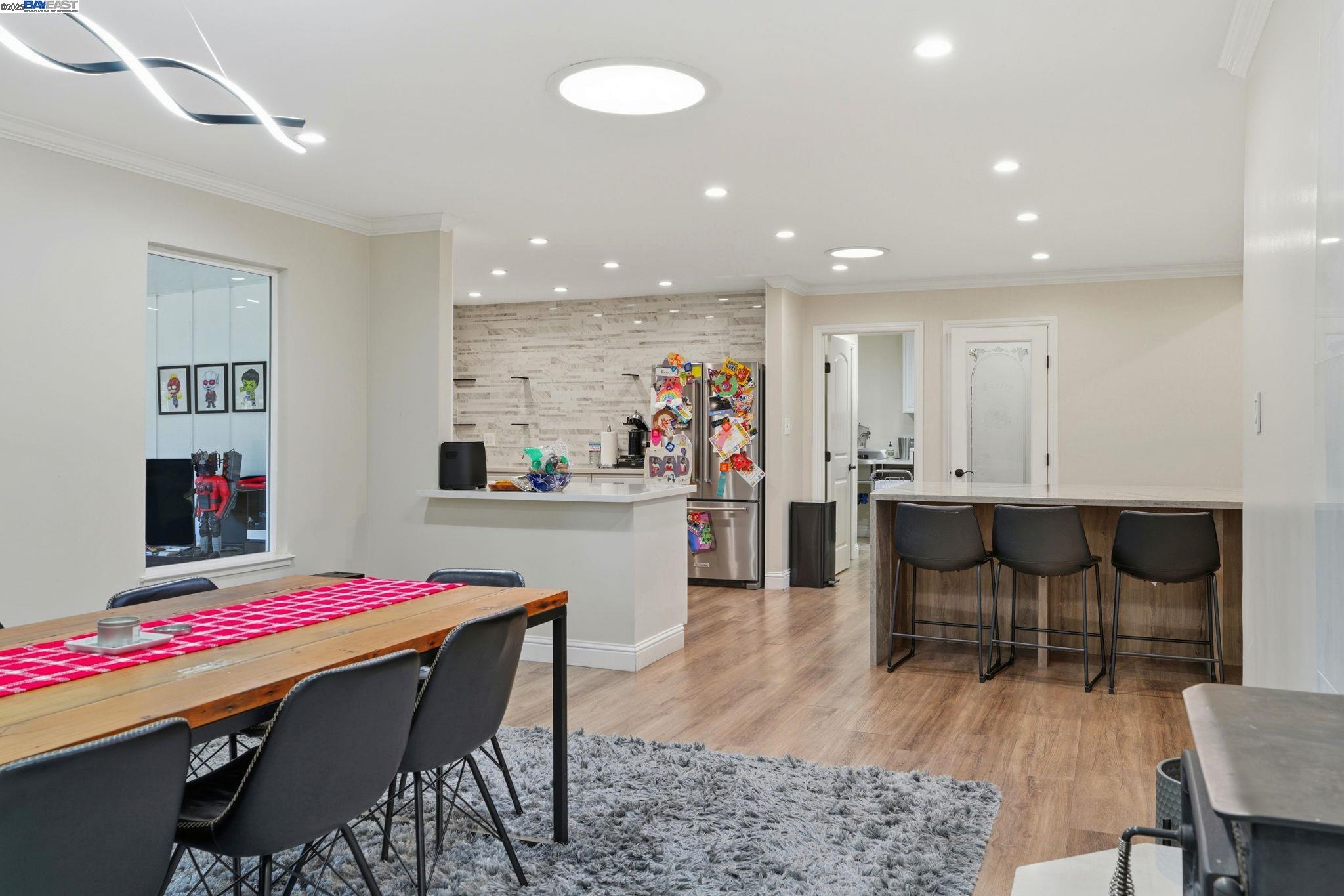 34724 Bernard Road Tracy, CA 95377 - Photo 24 of 60 a dining room with kitchen island a dining table wooden floor and a rug