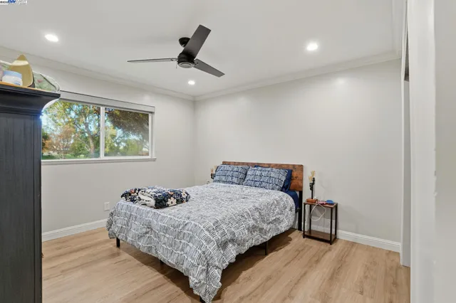 a bedroom with a bed and a ceiling fan
