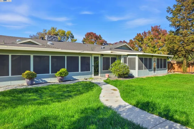 a view of a house with a backyard and a tree