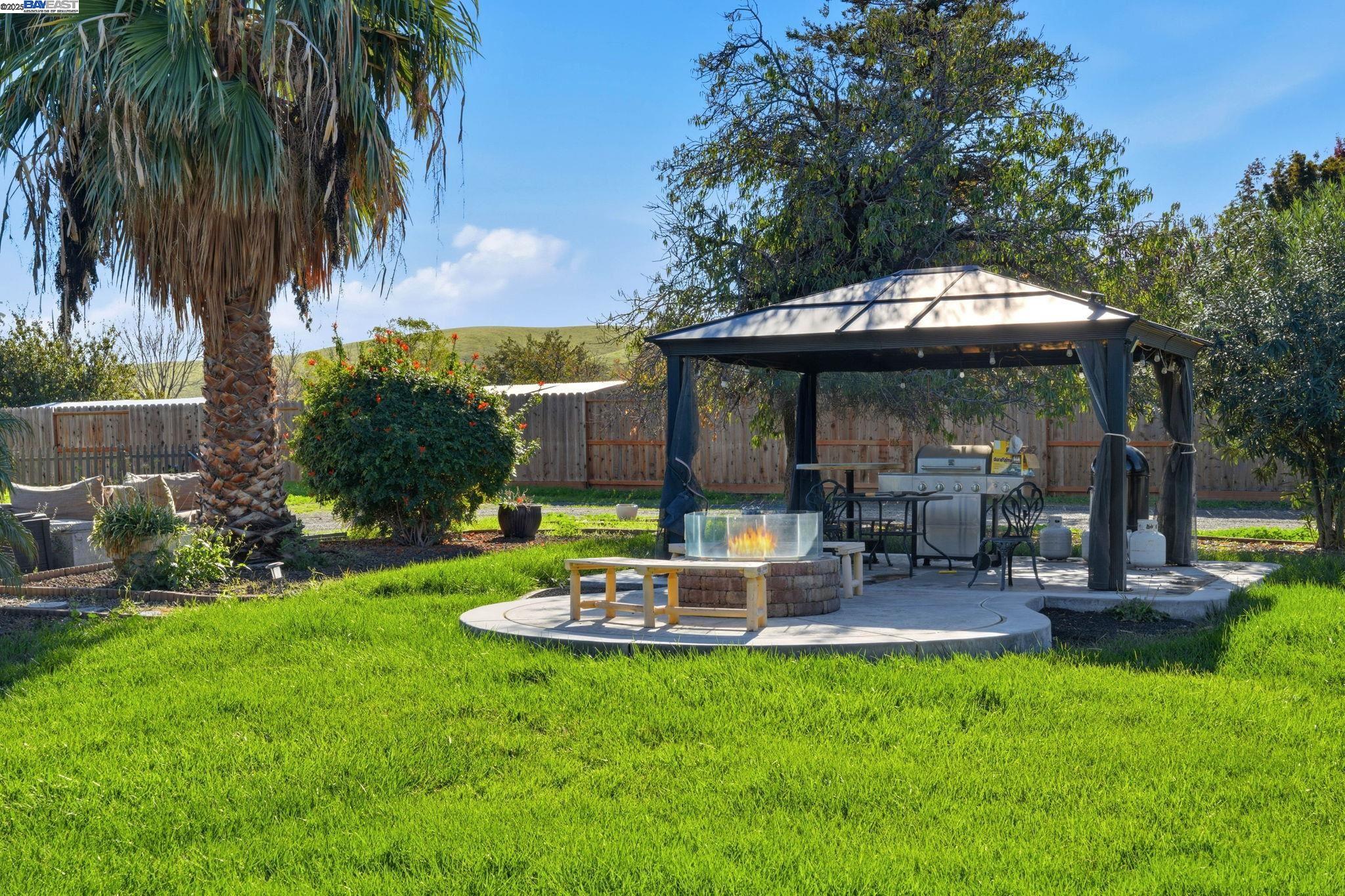 34724 Bernard Road Tracy, CA 95377 - Photo 50 of 60 a view of a patio with table and chairs potted plants and palm tree