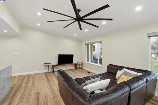 a living room with furniture and a wooden floor