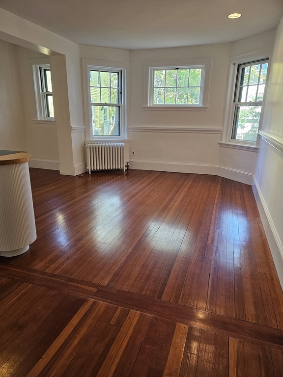 361 Harvard Street, Unit 2 Cambridge, MA 02138 - Photo 1 of 8 an empty room with wooden floor and windows