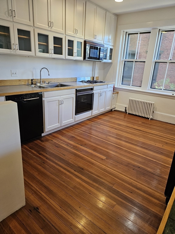 361 Harvard Street, Unit 2 Cambridge, MA 02138 - Photo 3 of 8 a kitchen with stainless steel appliances granite countertop a sink dishwasher stove and cabinets
