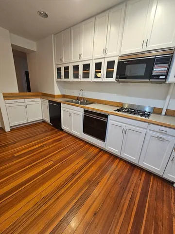 a kitchen with stainless steel appliances granite countertop a stove a sink and a microwave