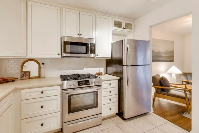 a kitchen with cabinets stainless steel appliances and wooden floor