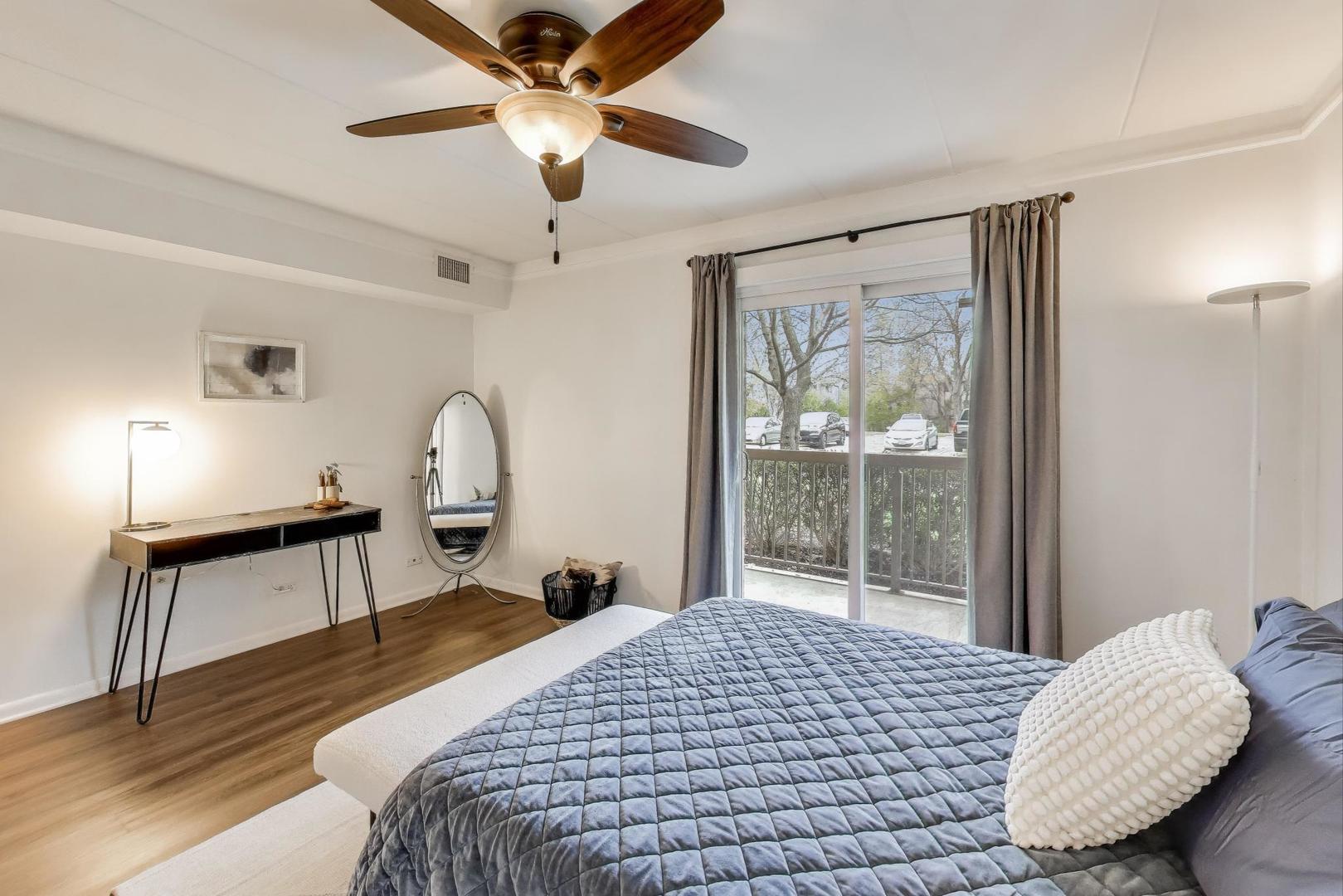 6443 Clarendon Hills Road, Unit 100D Willowbrook, IL 60527 - Photo 17 of 31 a bedroom with a bed and a chandelier