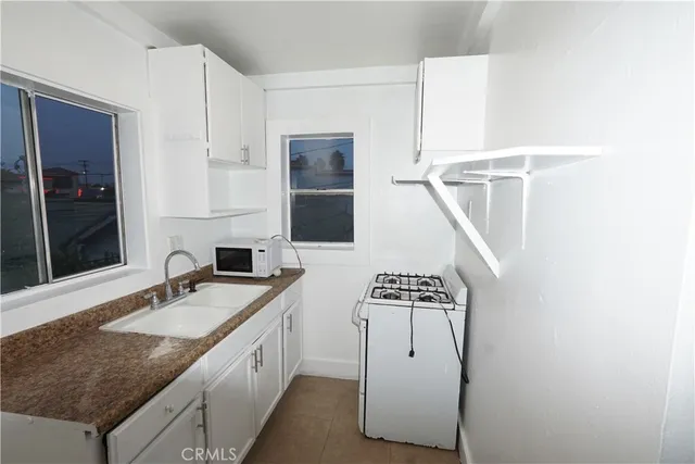 a spacious bathroom with a granite countertop sink and a mirror